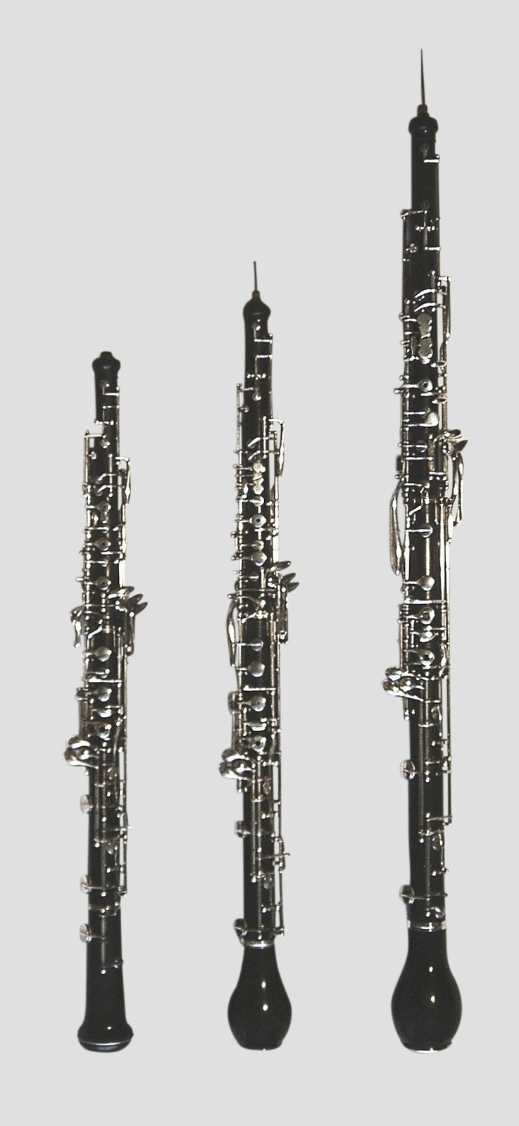 Trzy instrumenty z rodziny oboju ustawione obok siebie: obój, obój miłosny i rożek angielski.