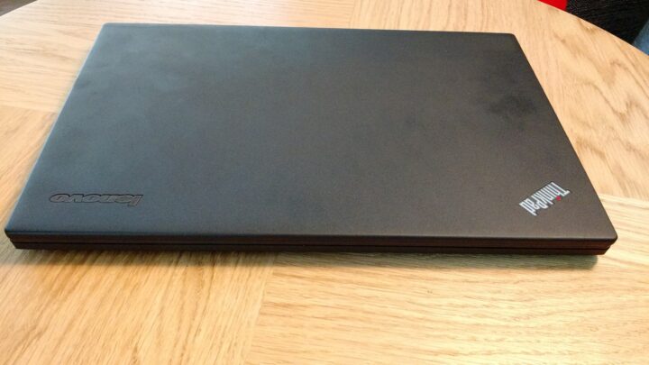 Zamknięty laptop Lenovo ThinkPad X240 leżący na powierzchni, fotografia archiwalna.