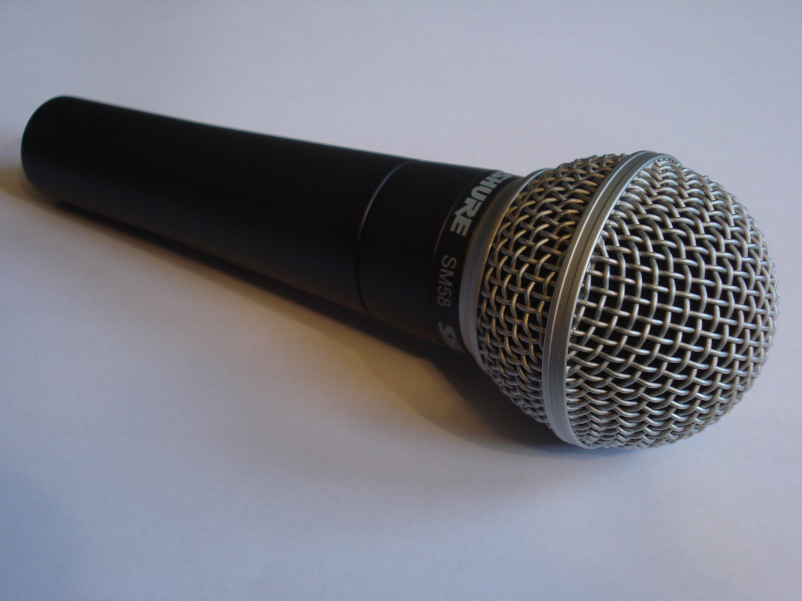 Rzeczywisty mikrofon dynamiczny Shure SM58 na jasnym tle.