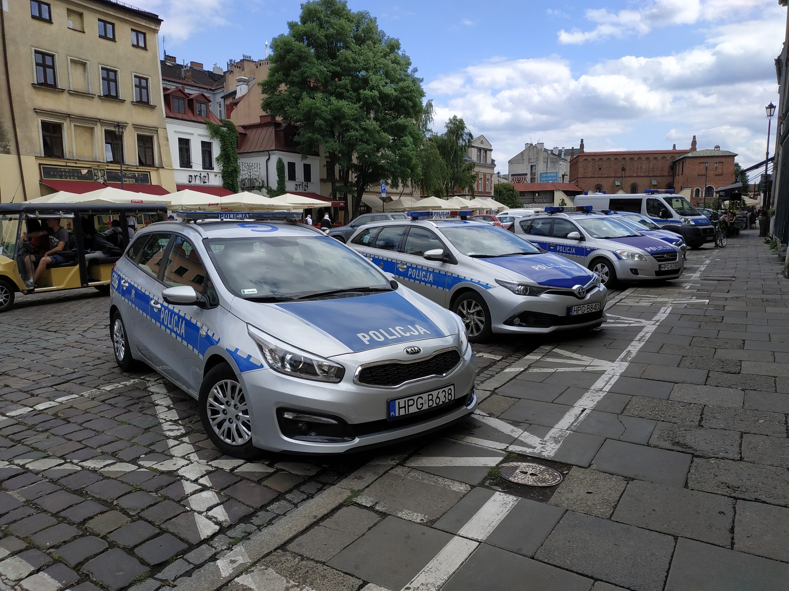 Oznakowane samochody polskiej policji zaparkowane na ulicy w Krakowie.