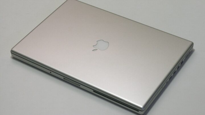Zamknięty srebrny MacBook Pro na jasnym stole.
