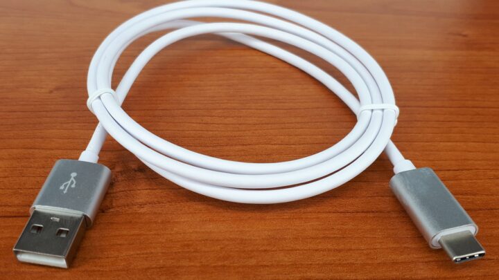 Biały kabel ze złączami USB-A i USB-C na drewnianym blacie