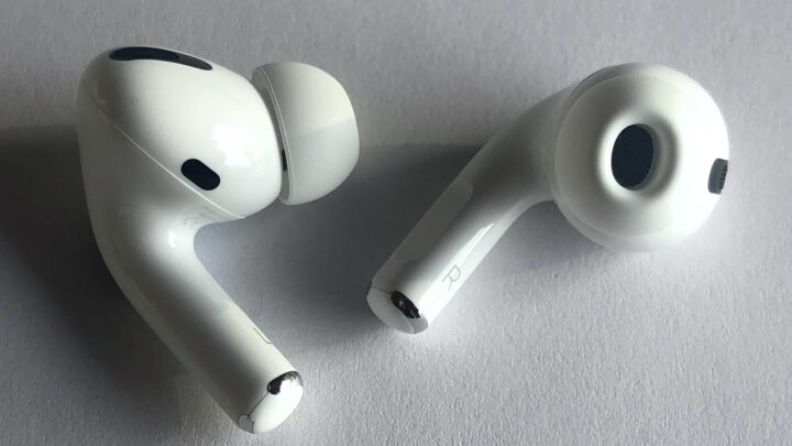 Białe słuchawki AirPods Pro leżące na jasnym podłożu
